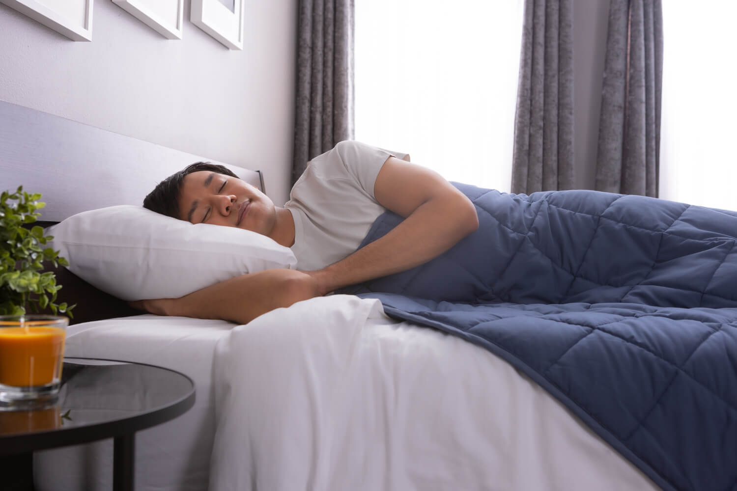 Man peacefully resting in bed, with Classic Weighted Blanket spread across his body 